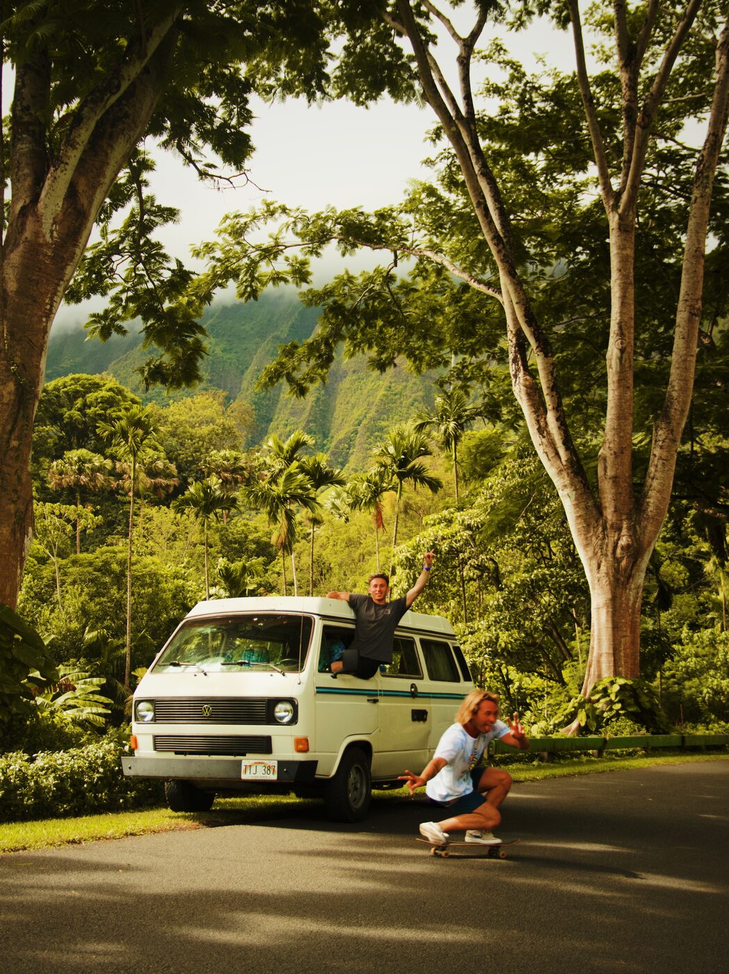Jaro and a friend with a VW van and skateboard on a jungle road, backpacking vibes