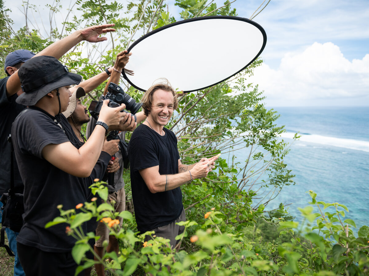 Jaro laughing with his content crew on a cliffside during a shoot