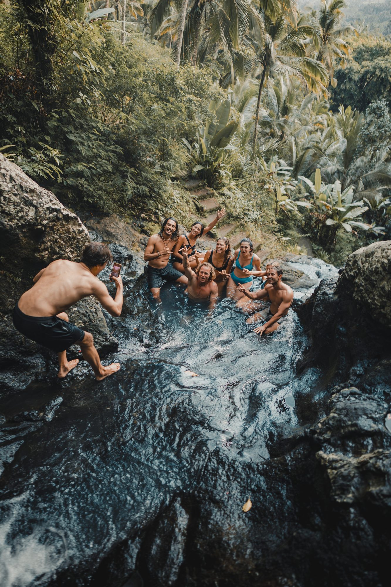 Jaro and friends cheering from a jungle waterfall pool in Bali